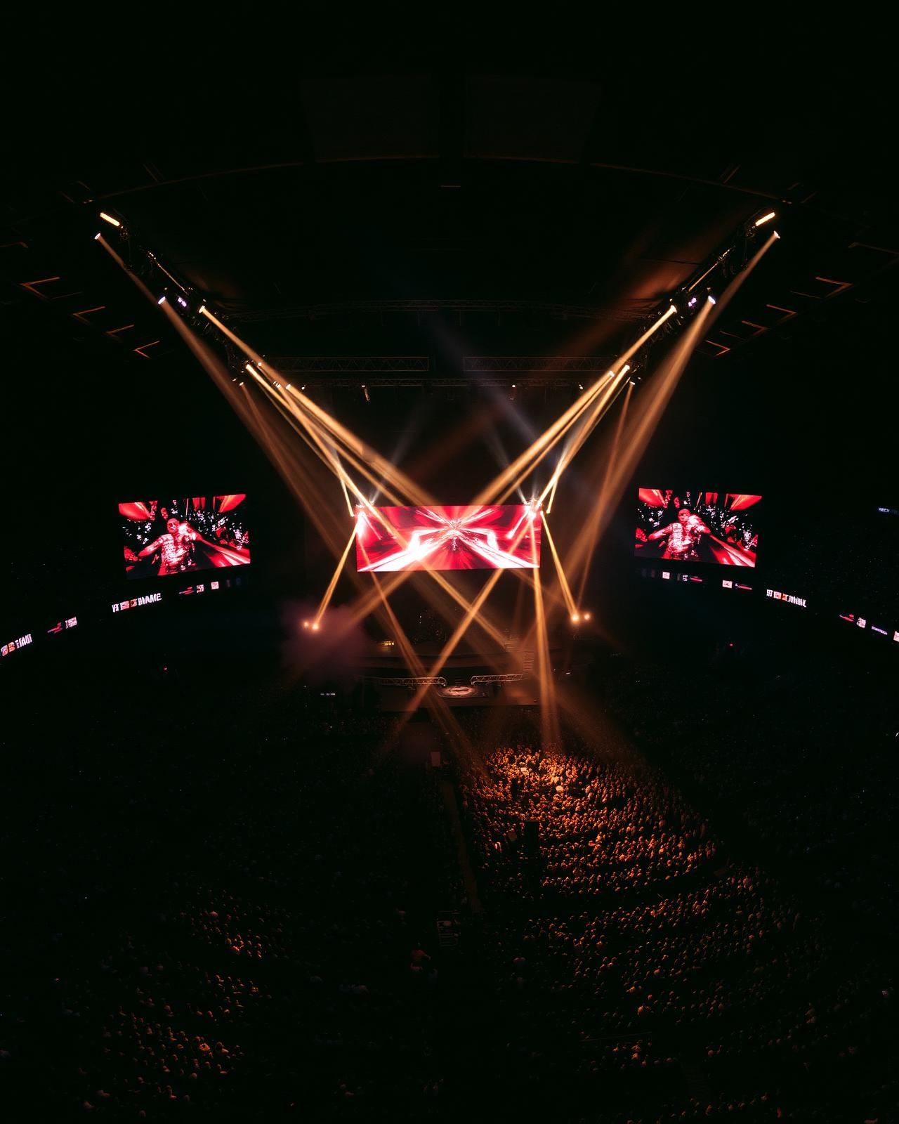 Aerial view of a massive arena crowd under cinematic stage lights